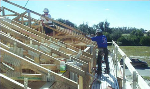 Figura 2 - Trabajador utilizando un andamio de soporte exterior para instalar armaduras de techo.