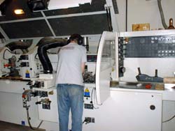 Employee wearing protective hearing device while working with the moulder