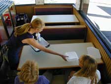 Over-reaching across tables or booths.