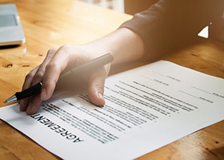 Person reading and signing agreement